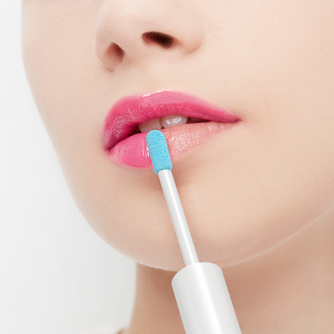 Person applying pink lip color with a blue applicator on a white background