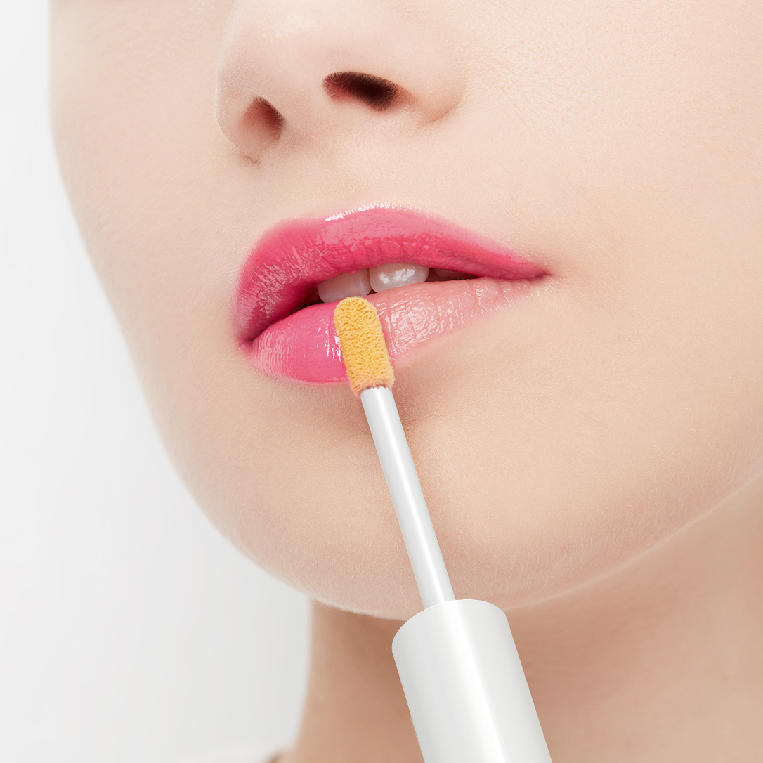 Close-up of a person applying lip balm with a small applicator on a white background